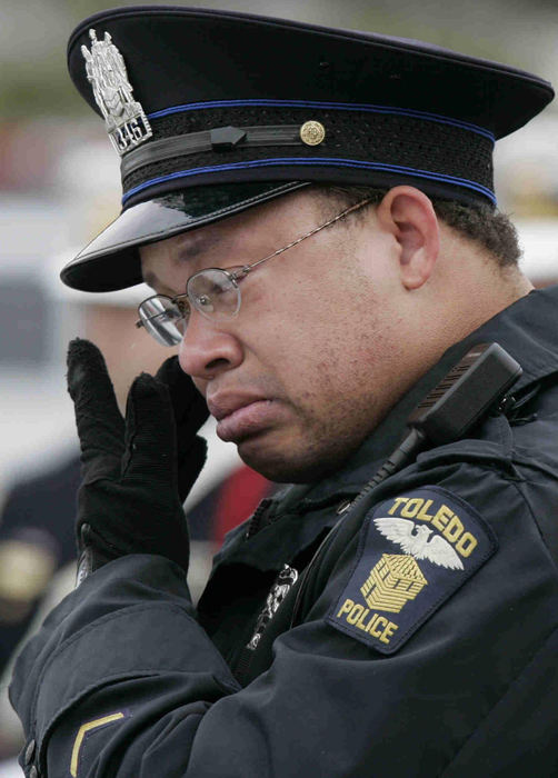 Award of Excellence, Team Picture Story - Dave Zapotosky / The BladeToledo police officer Tyson Coates wipes tears from his eyes as the last radio call to Det. Keith Dressel is played at his funeral mass.