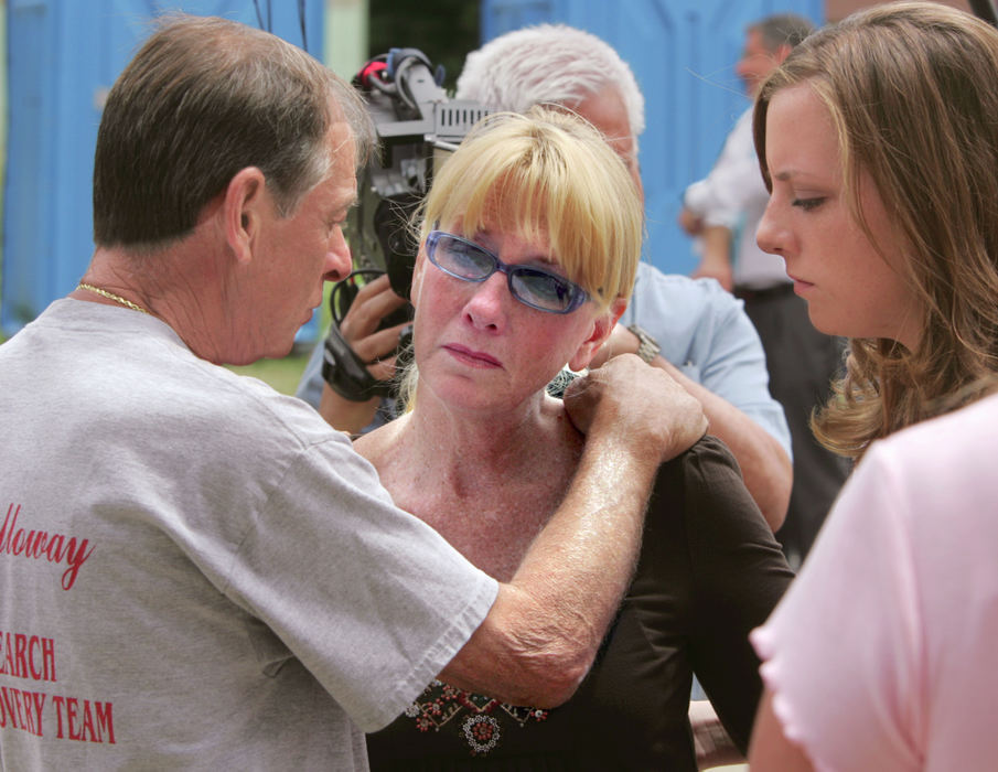 First Place, Team Picture Story - Phil Masturzo / Akron Beacon JournalTim Miller (left), founder of EquuSearch, talks with Patty Porter (center), mother of Jessie Marie Davis, and the missing woman's sister, Whitney Davis, at the Greentown Fire Department midday on June 23, 2007 in Uniontown. Porter was being told that authorities had discovered Jessie's body and that of her unborn daughter on the 10th day of a massive search and coincided with the arrest of her son's father, Canton police officer Bobby Cutts Jr. The bodies were discovered some 25 miles for the search site.