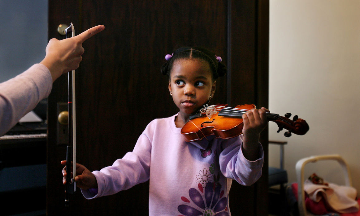 Award of Excellence, Feature - Gus Chan / The Plain DealerZarhia Blue puts her violin under her chin and raises her bow to the vertical position as she waits for the cue from teacher Yuko Nakamura.  The five-year-old takes Suzuki violin at the Broadway School of Music & the Arts.