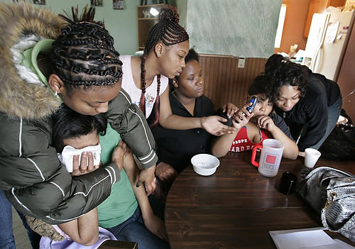 First Place, Feature Picture Story - Chris Russell / The Columbus DispatchLaDawnya Ruffin is comforted by family and friends as they listen to the last message her son Melvin Ruffin,15, left on her phone before he was killed on his way home from a local library. 