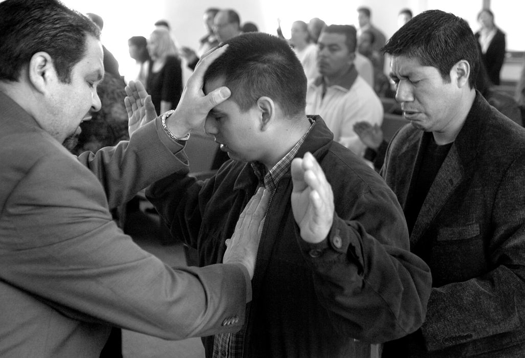 Third Place, Feature Picture Story - Carrie Cochran / The Cincinnati EnquirerPastor Josh Colon of the Princeton Pike Church of God in Hamilton rests his hands on a church member. "No matter what happens in the city of Hamilton.... no matter what people hear about this community, this is a place where people can feel the peace of God, and know that they're going to receive motivation and hope for their everyday lives," Colon said.