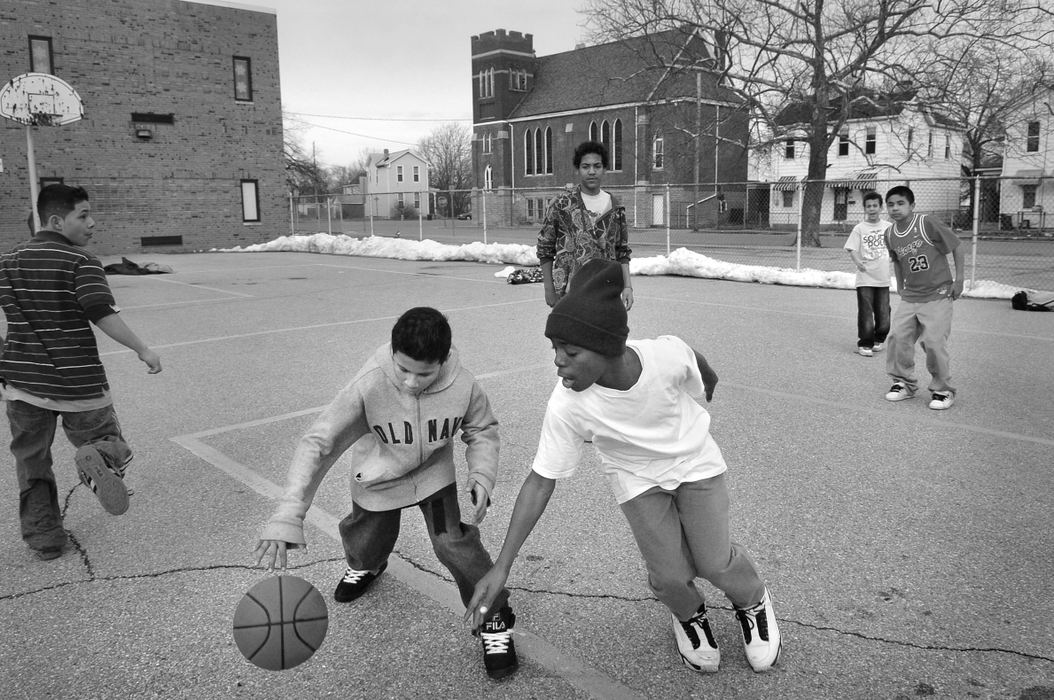 Third Place, Feature Picture Story - Carrie Cochran / The Cincinnati EnquirerChildren play basketball March 1,2008 in the Fourth Ward of Hamilton, where there is a significant population of Hispanics and African-Americans. Just a few blocks away in June 2005, a 9-year-old white girl was allegedly raped by a Mexican man who was in the country illegally. The incident sparked racial unrest towards Hispanics and even brought the Klu Klux Klan to the area. 