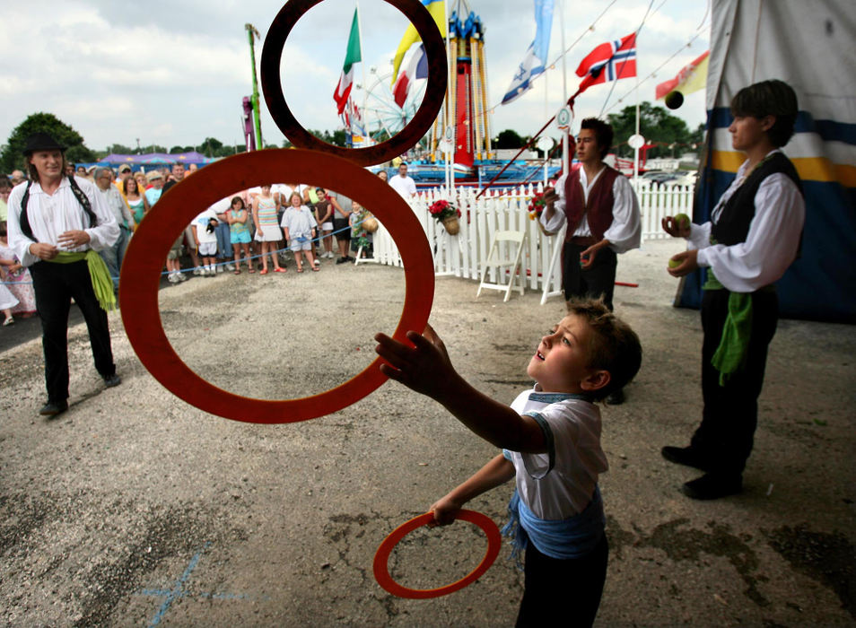 Award of Excellence, Feature Picture Story - Lisa DeJong / The Plain DealerAcrobat Adrian Poema Jr., 5,  juggles rings hoping to attract people to buy tickets for their circus. Adrian is part of "The Poema Family", acrobats originally from Argentina.