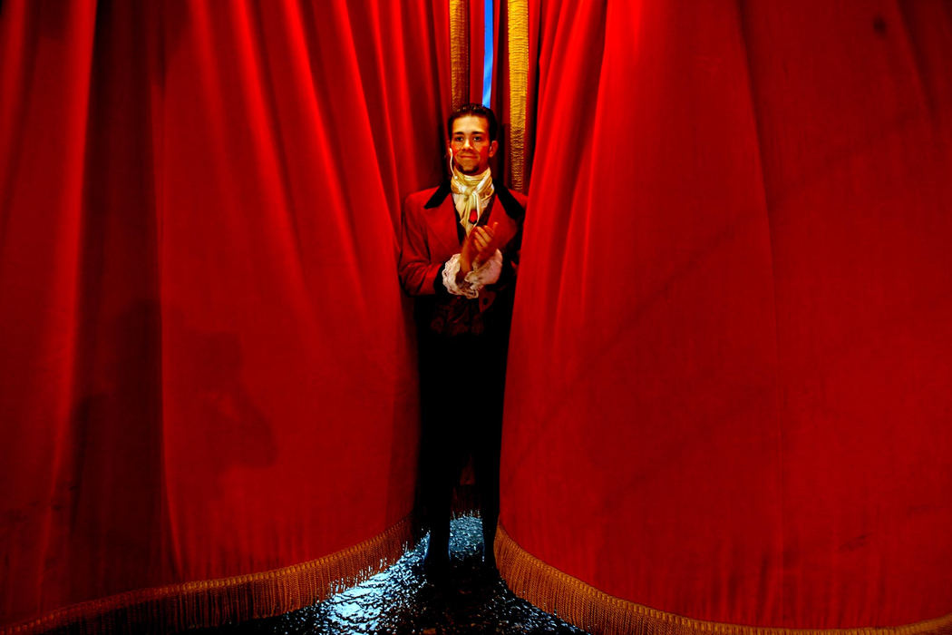 Award of Excellence, Feature Picture Story - Lisa DeJong / The Plain DealerRingmaster Tom Eggers claps for the performers as he tries to keep the velvet curtains from blowing inward caused by the fierce rainstorm outside in Canton. 