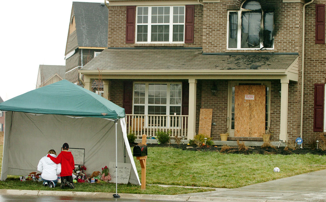 Award of Excellence, General News - Carrie Cochran / Cincinnati EnquirerVisitors to the memorial in front of the Veillette home in Mason are photographed January 13, 2007. There were several visitors to the site, mostly people who drove by in their car.  Michel Veillette is charged with the murder of his wife and four children after he and his wife's body were found with stab wounds following a house fire Friday evening. He was charged with starting the fire to cover up the murders. Michel later hung himself in his jail cell in the Warren County Correctional Facility while he awaited the completion of his trial.