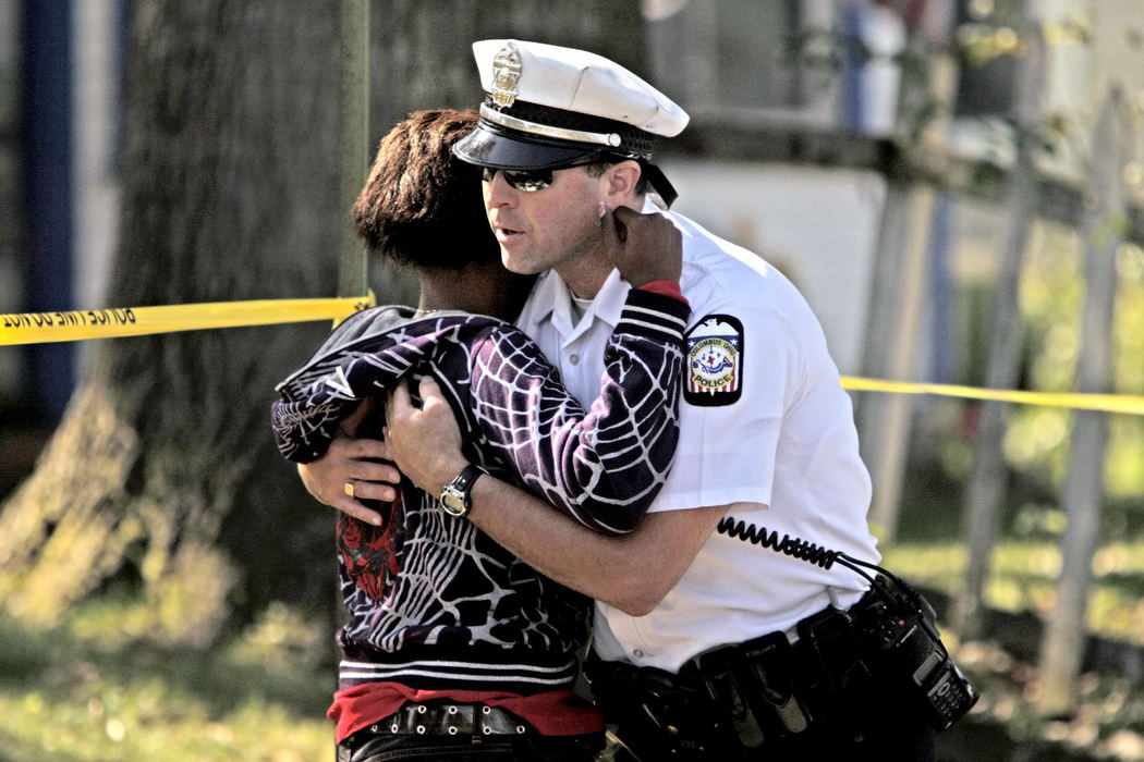First Place, News Picture Story - Fred Squillante / The Columbus DispatchA Columbus police officer intercepts a distraught woman who had just arrived on the homicide scene; she was trying to get to the house with the bodies in it.