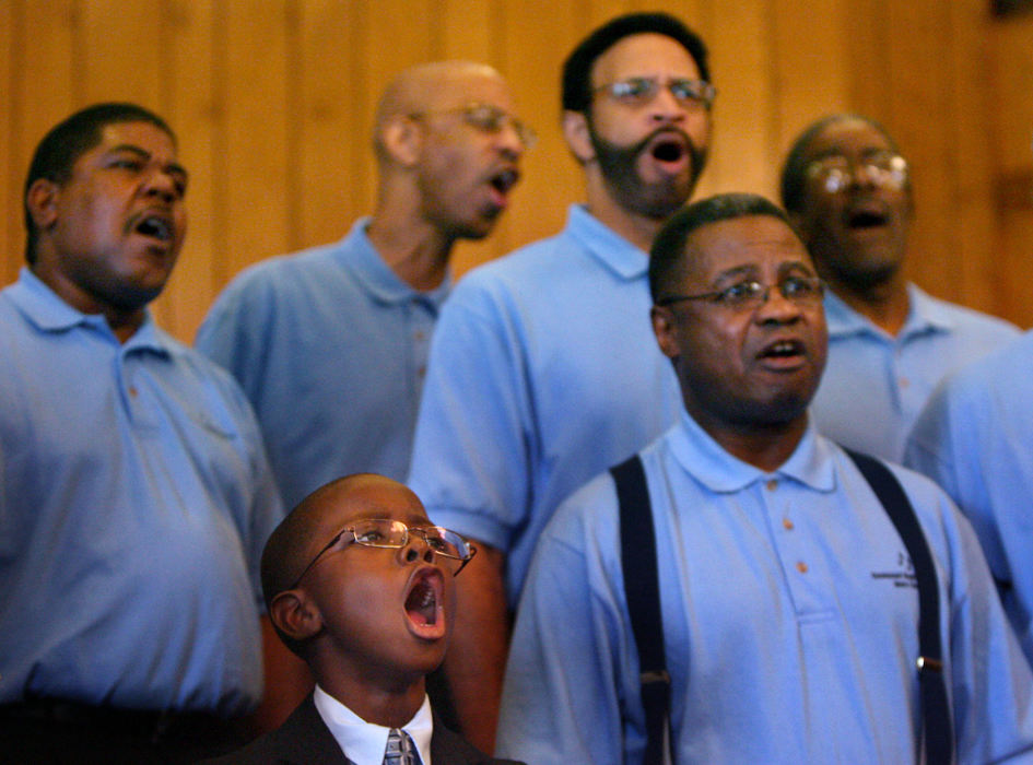 Award of Excellence, News Picture Story - Tracy Boulian / The Plain DealerWhether the pews are full or not, soul shaking music rings out from the choir every Sunday. The church uses the choir and other membership groups to urge members to spend extra time around the safety of the church. Without a large membership, the church had to mix adult and children's choirs, rather than offering separate groups. Marvin Davies IV, 6, front, and members of the men's choir sing during the Sunday service at Emmanuel Baptist Church in Cleveland on Sept. 21, 2008. 