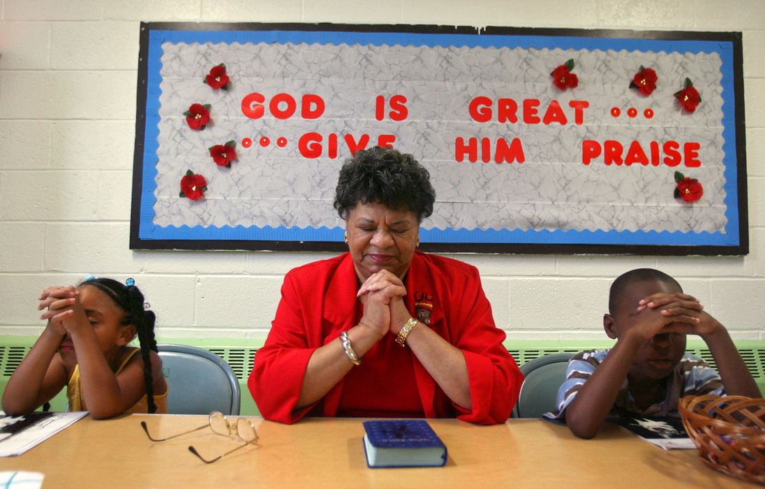 Award of Excellence, News Picture Story - Tracy Boulian / The Plain DealerInstiling a set of morals in the children at the church and at the same time keeping them safe, is one of the missions of the church. Lenora Smoot leads Nakiah Thornton, 7 (left)and Jamir McCulley, 9, in prayer during a Sunday school class at Emmanuel Baptist Church. 