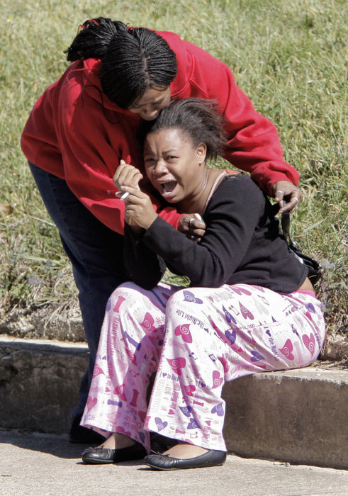 First Place, News Picture Story - Fred Squillante / The Columbus DispatchTwo women mourn at the scene of a triple homicide where two men and a woman were found shot to death in a duplex.