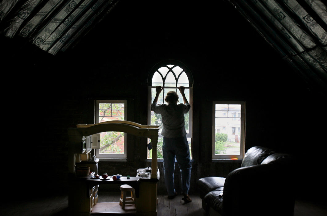 Award of Excellence, News Picture Story - Gus Chan / The Plain DealerLinda Shay closes a third floor window in a house she purchased and is renovating.  Shay was arrested for growing more than 250 marijuana plants in her basement and backyard.