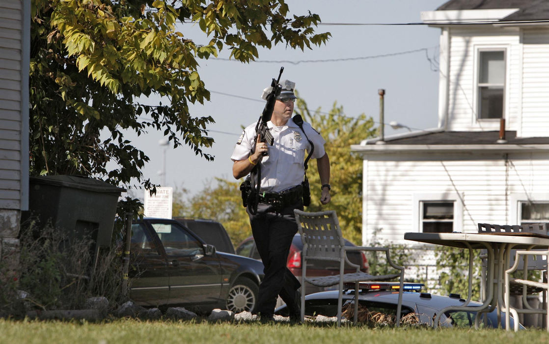 First Place, News Picture Story - Fred Squillante / The Columbus DispatchA Columbus police officer responds to the sound of gunfire in an alley behind the duplex where three bodies were found. Police were already on the scene investigating the murders when the shots were fired.