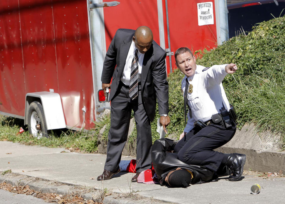 First Place, News Picture Story - Fred Squillante / The Columbus DispatchHomicide detective Vince Houpe (left) stands by as Sgt. Rich Weiner (right) yells at bystanders to move back. Some of the bystanders were yelling at police that the man being detained was a member of the victim's family. The man was later released.