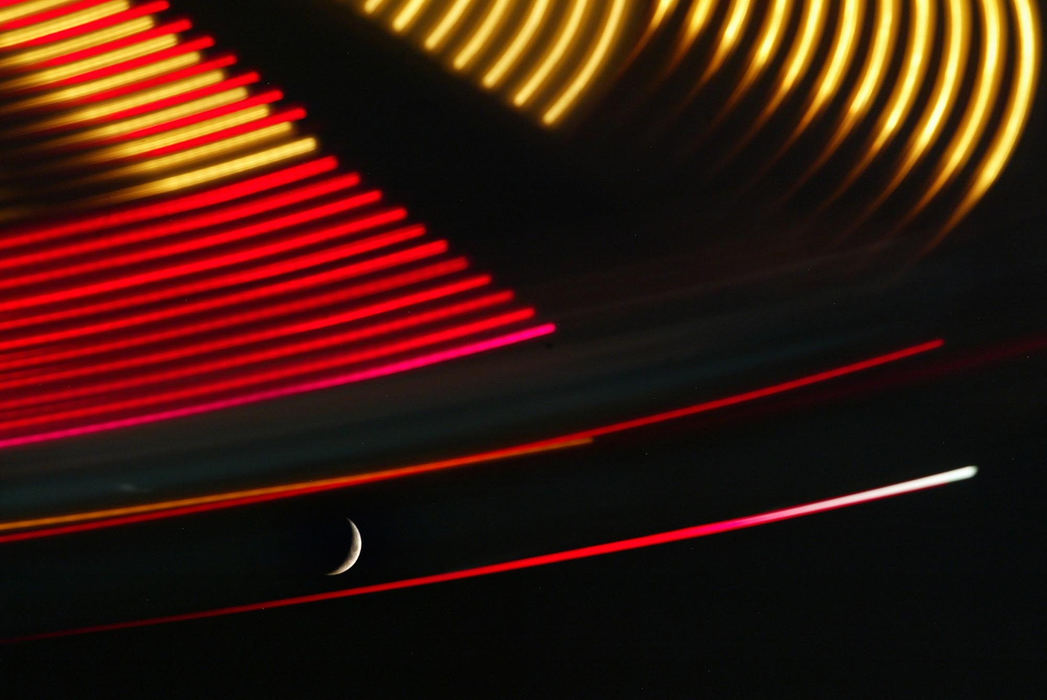 Second Place, Pictorial - Tim Norman / ThisWeek Community NewspapersThe moon is framed by the lights of the Hurricane ride as passengers fly across the night sky at the Reynoldsburg Tomato Festival at Reynoldsburg Civic Park on September 3, 2008.