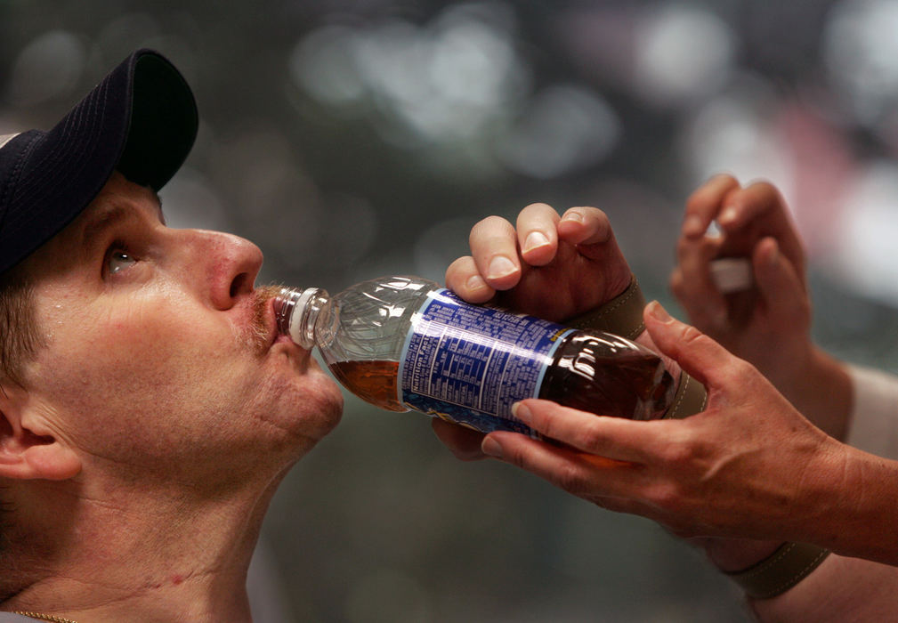 Third Place, Photographer of the Year - Gus Chan / The Plain DealerNorm Martin tips back a bottle of Brisk ice tea with the help of his therapist, Kathy Stroh.  Martin is slowly regaining the use of his hands after an industrial accident. 