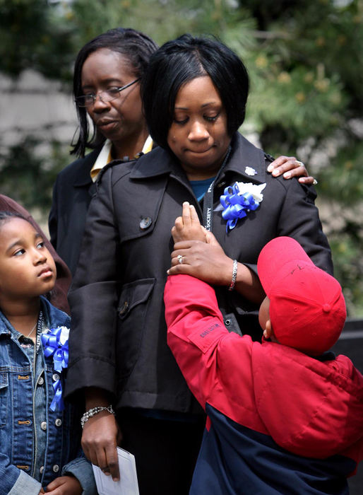 First Place, Photographer of the Year - Lisa DeJong / The Plain DealerChandler Owens, 6, on bottom right, tries to wipe a tear away from the face of his mother, Ericka Owens, as his sister Sydni, 8, left, looks on during the 2008 Greater Cleveland Peace Officers Memorial Service at Huntington Park.  The family was presented a plaque in honor of Cleveland Police Officer Derek Owens, Ericka's husband, who was killed in the line of duty.