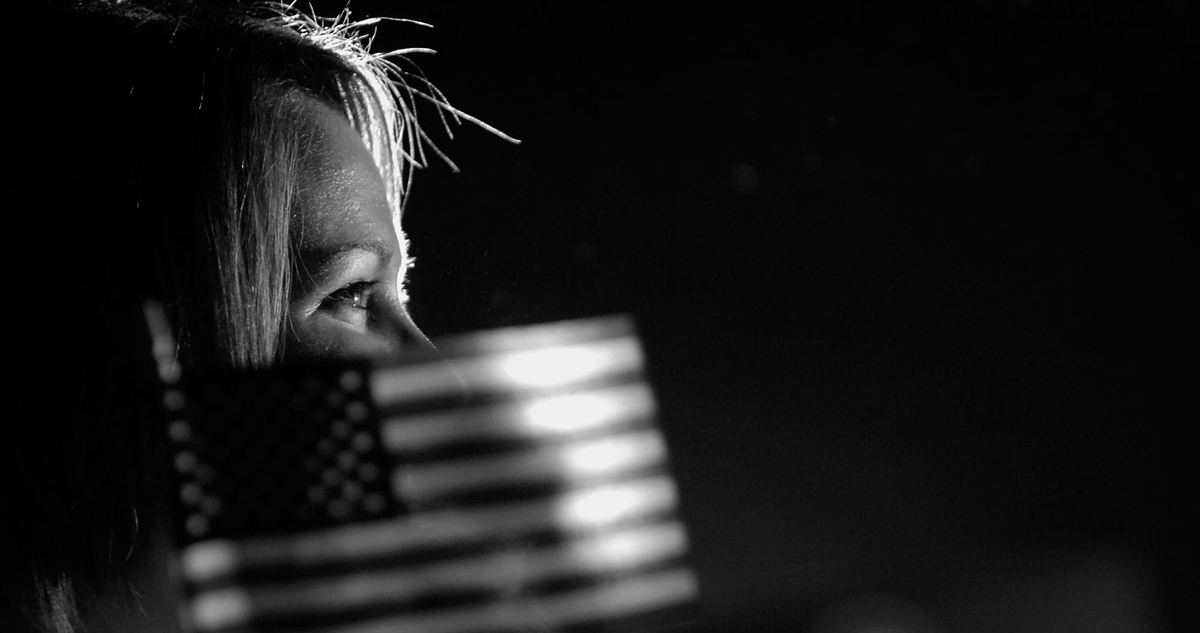 Second Place, Photographer of the Year - Michael E. Keating / Cincinnati EnquirerAt a nighttime rally, a supporter with a flag, like thousands throughout the day, was fresh eyed and excited to see her candidate.  It had been a long wait, but the smile in her eye reflected her pleasure. 