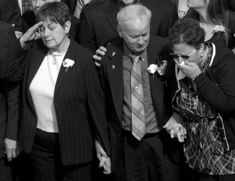 Second Place, Photographer of the Year - Michael E. Keating / Cincinnati EnquirerFrom left, the mother of a fallen firefighter Brian Schira, the father and mother of Robin Broxterman display a wide range of emotion as they wait for the caskets to be placed on fire trucks following the church service. 