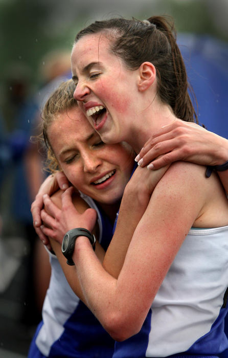 First Place, Photographer of the Year - Lisa DeJong / The Plain DealerCarolyn Case, 16, left, hugs Cuyahoga Valley Christian Academy teammate Katie Gillespie, 16, right, after she finished in first place in the women's 1600 meter run during the 28th annual Austintown Fitch Optimist meet in Youngstown  Gillespie finished second. Gillespie won the women's 3200 meter run. 