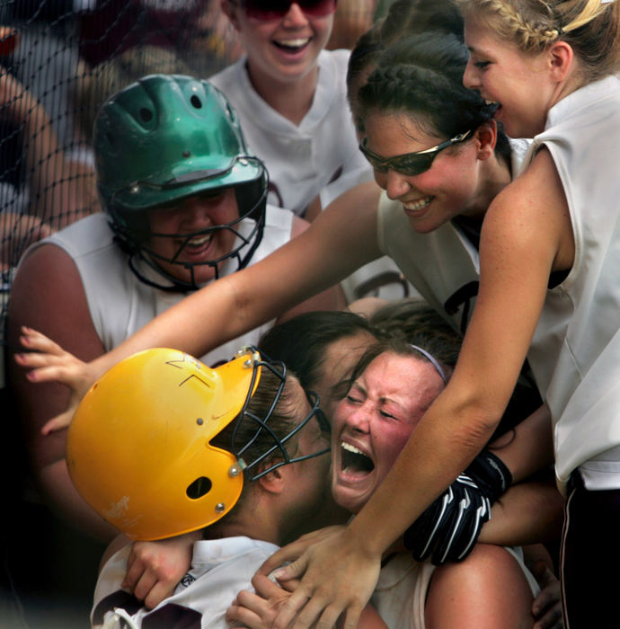 Third Place, Photographer of the Year - Gus Chan / The Plain DealerWellington's Callie McConnell, wearing the yellow batting helmet, is mobbed by teammates after scoring the winning run in extra innings.