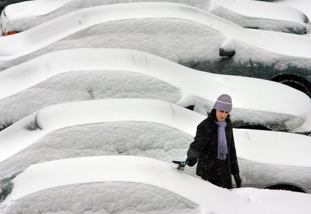 Third Place, Photographer of the Year - Gus Chan / The Plain DealerA woman brushes off her car in a parking lot on W. 3rd and Superior Ave.  All day snows caused massive traffic backups on all arteries leaving the city.