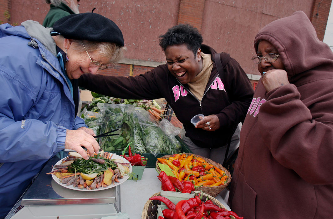 Third Place, Photographer of the Year - Gus Chan / The Plain DealerPam Petty, center, share a laugh with Pat Waina (left) while sampling some of the offerings from Blue Pike Farm, an urban farm situated in the city of Cleveland.