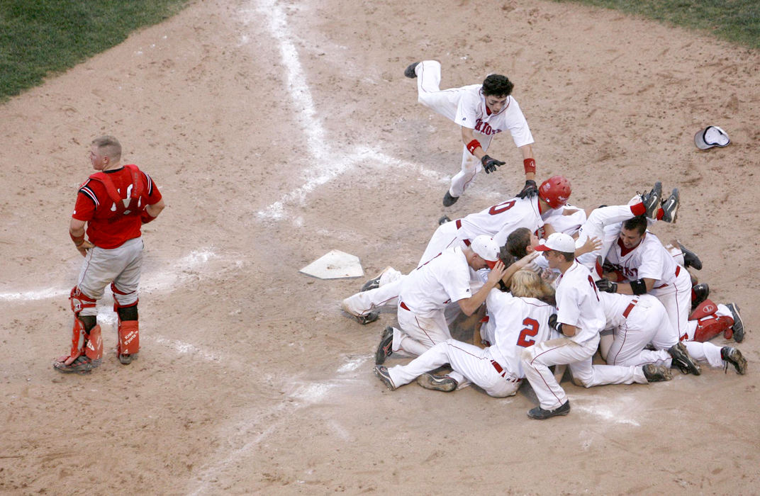 Award of Excellence, Sports Feature - Scott Heckel / The RepositoryPatrick Henry players mob Cody Meyer after he crossed the plate with the winning run in the Division IV state championship game in Columbus. Patrick Henry defeated Highland 10-0 in the game which ended after five innings due to the OHSAA's mercy rule. Highland catcher Justin Miller is visible at left. 