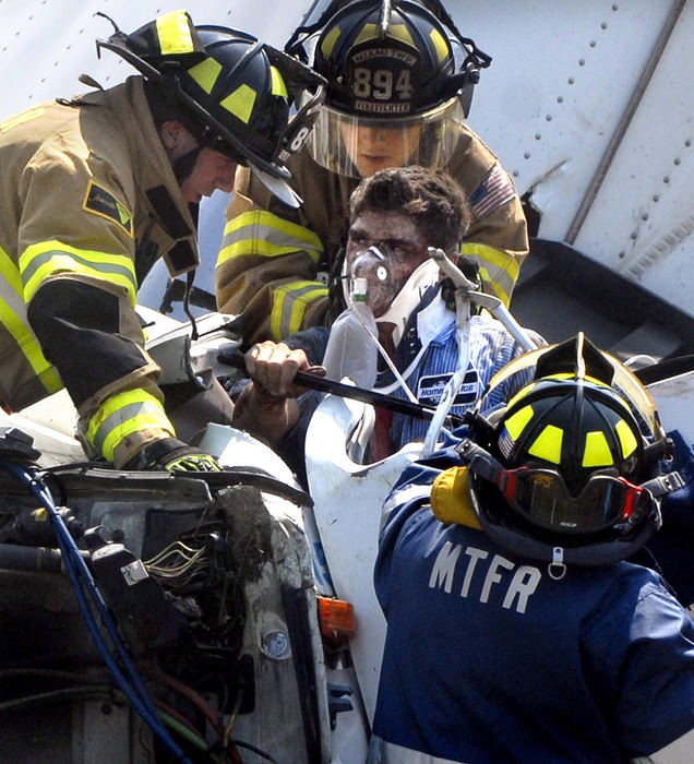 Award of Excellence, Spot News under 100,000 - Marshall Gorby / Springfield News-SunMembers of the Miami Township Fire-Rescue pull the driver of a Home City Ice truck from the cab after it rolled over on Ohio 343 near Yellow Springs, Sept 3, 2008.