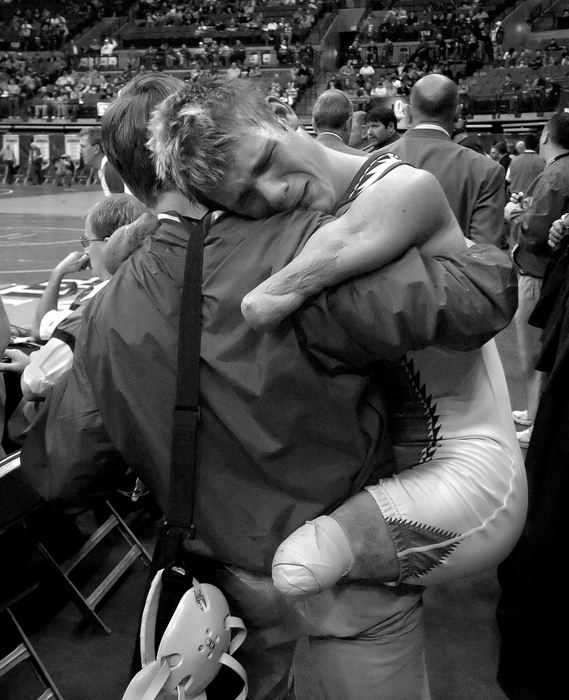 First Place, Sports Picture Story - Michael E. Keating / Cincinnati EnquirerDustin Carter is carried from the arena floor by his coach after he was eliminated from the tournament. His tears of disappointment were later replaced by his pride in "achieving a lifelong dream of participating in the state finals".