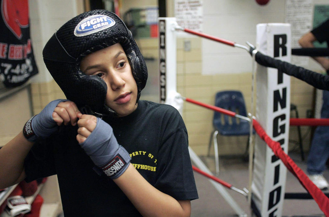 Second Place, Sports Picture Story - Andrea Kjerrumgaard / The Columbus DispatchEleven-year-old Terrell Fairrow has been boxing for the Chillicothe-Ross County Police Athletic League for four years.  But his involvement isn't just about the boxing;  it's also about seeing in his coaches the "dad I never had."  Because of substance abuse, Fairrow's parents aren't around.  He and his three siblings are being raised by their ailing great-grandparents, Terrell Fairrow, 11, secures his headgear before going in the ring to spar during practice at the Chillicothe-Ross County Police Athletic League Monday, February 25, 2008.  