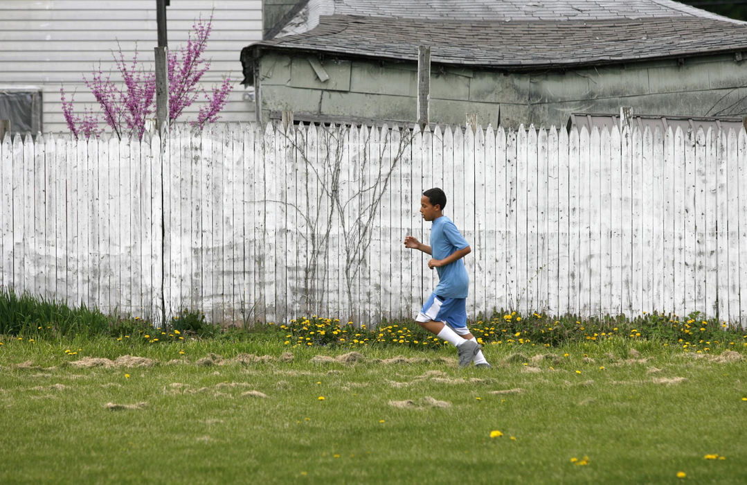 Second Place, Sports Picture Story - Andrea Kjerrumgaard / The Columbus DispatchDuring a weekday practice, Terrell Fairrow runs laps on the ground of the Ross County Police Athletic League in Chillicothe. 