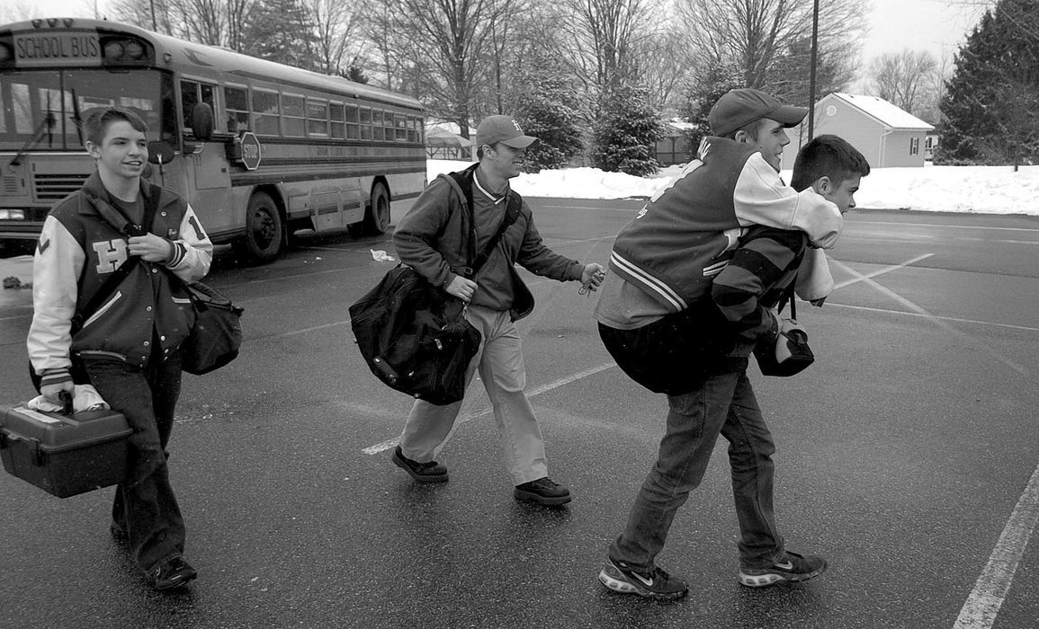 First Place, Sports Picture Story - Michael E. Keating / Cincinnati EnquirerA friend carries Dustin Carter to a match to save wear and tear on his leg stumps. His stumps are very sore and tender due to his training schedule. Hillsboro high school wrestler Dustin Carter lost his arms and legs to a childhood blood infection. He had only one loss during the regular season and made the OHSAA State Finals.  He did not win a match at the state championship but won the hearts of the crowd and was given a special recognition and inducted into the wrestling hall of fame, resulting in a standing ovation at the end of the meet.