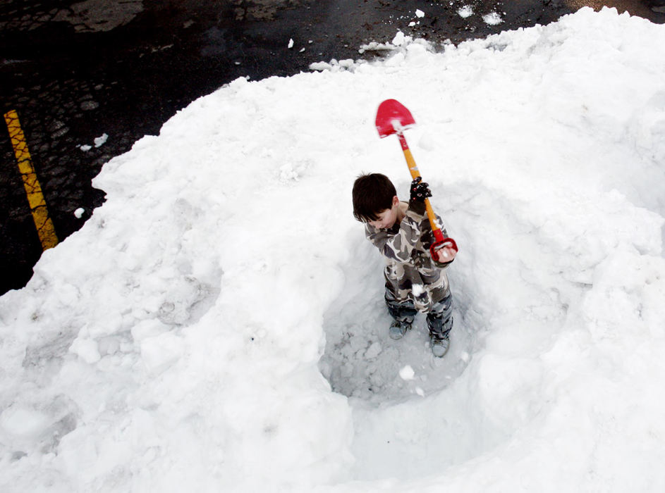 First Place, Team Picture Story - Eric Albrecht / The Columbus DispatchCecil Collins, 11, along with neighborhood friends dig out a mound of snow for a igloo and a sledding hill next to their Hilltop homes. The snow was piled up in a parking lot belonging  to dentist office. 