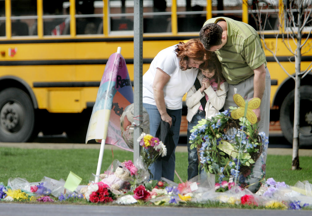 Second Place, Team Picture Story - Eric Albrecht / The Columbus DispatchAlaina Wickersham, 8, along with parents Cinda and Mark Wickersham, offer a prayer for crossing guard Dianna Sharp at a makeshift memorial at the school. Alaina is a student at the school.