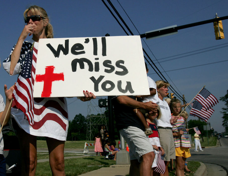 Third Place, Team Picture Story - Marvin Fong / The Plain DealerLaura Powaski reacts as the funeral procession for Twinsburg Patrolman Joshua Miktarian passes by.  The motorcade passed children on bicycles, young mothers with babies in strollers, and elderly men an women using canes.