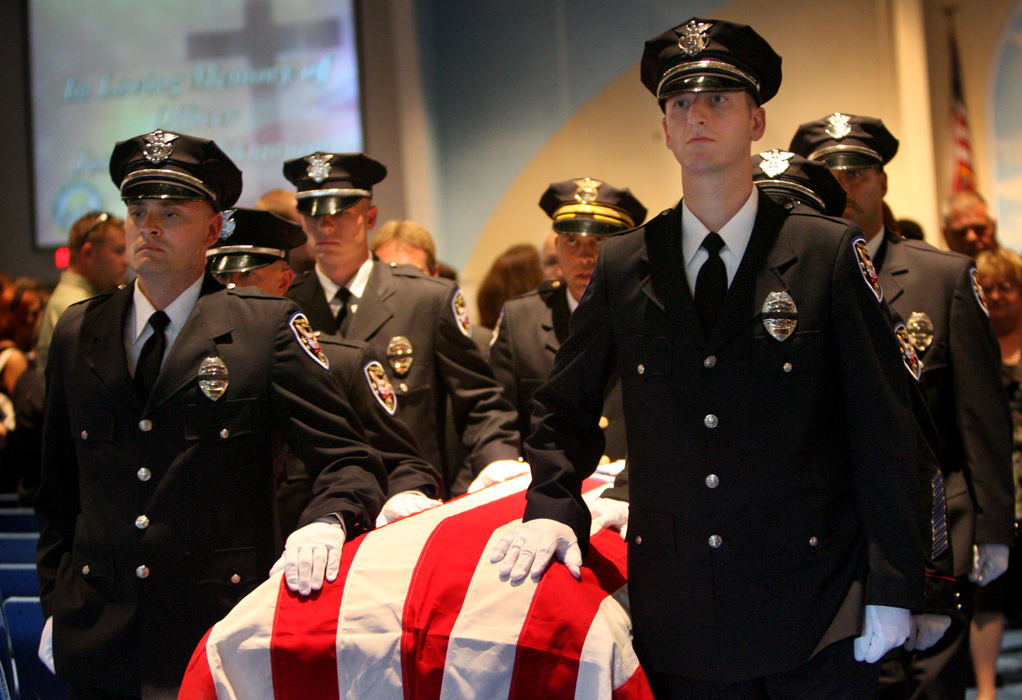 Third Place, Team Picture Story - Tracy Boulian / The Plain DealerTwinsburg police officers walk the casket down the center aisle of  Mt. Zion Baptist Church in Oakwood Village.  More than 4,000 people filled the church to remember the slain patrolman.