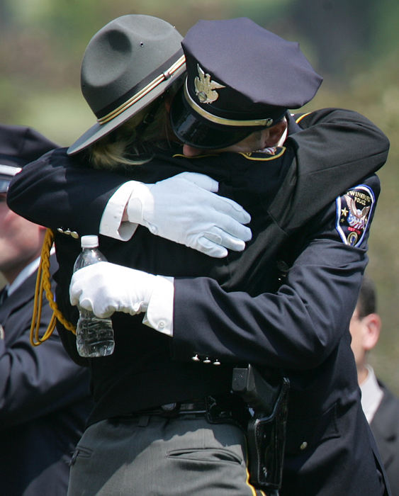 Third Place, Team Picture Story - John Kuntz / The Plain DealerAn Ohio state trooper, left, offers condolences to a Twinsburg officer after the internment ceremony.  