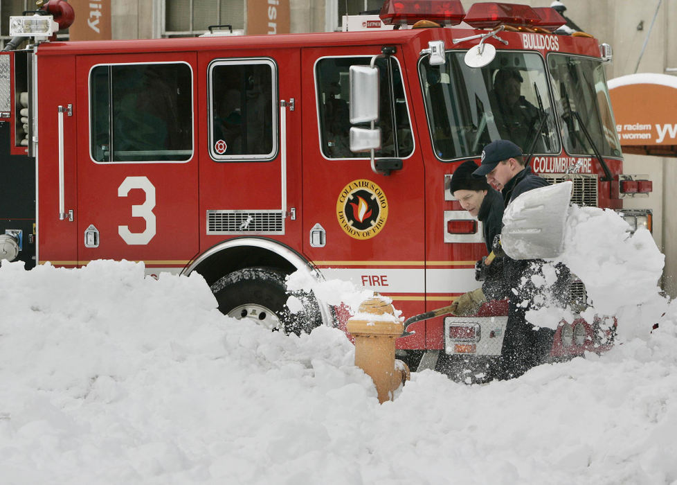 First Place, Team Picture Story - Neal C. Lauron / The Columbus DispatchColumbus firefighters work to clear off access to fire hydrants on 4th Street the day after record snows fell on Columbus. 