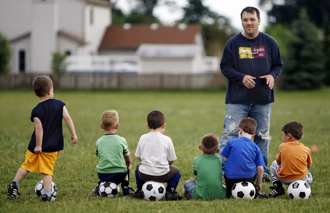 Third Place, Feature - Neal C. Lauron / The Columbus DispatchVann Norman, 3, of the Crew soccer team makes an adjustment to his malfunctioning shorts as coach Mike Scott goes over strategy during their weekly practice at the Buckeye Woods Elementary field, June 1, 2009. 