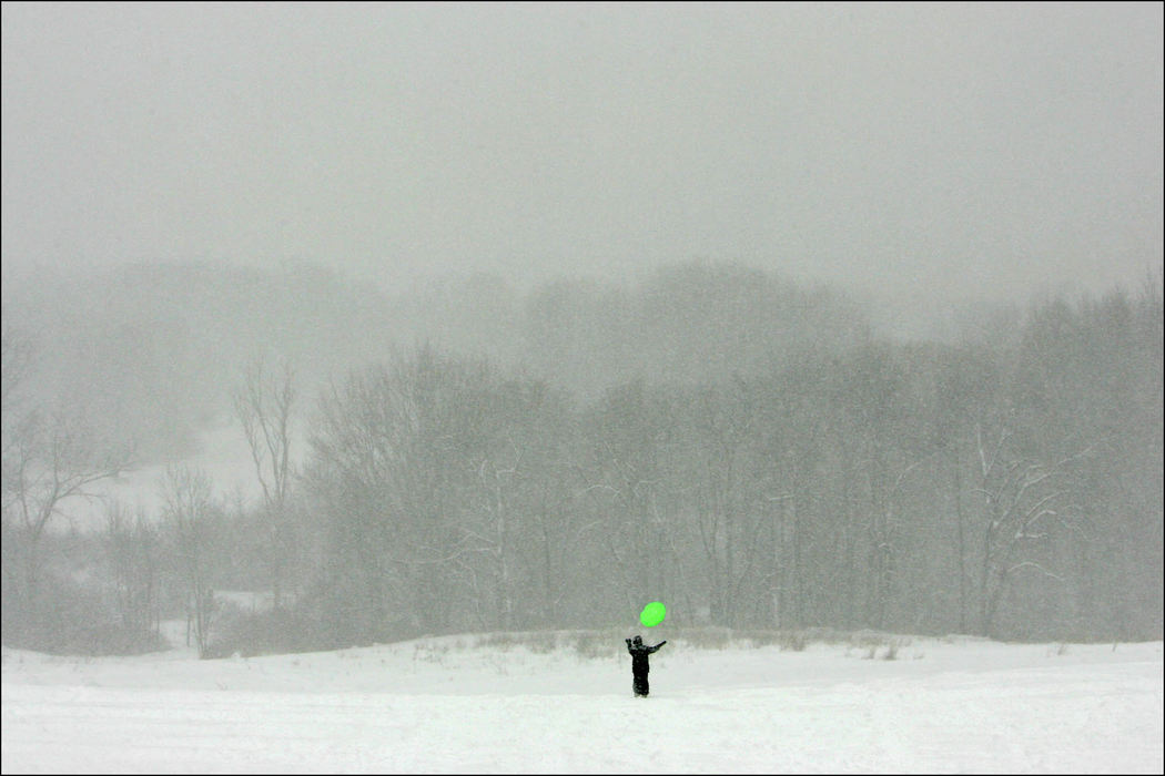 Award of Excellence, Feature - Ed Suba, Jr. / Akron Beacon JournalFalling snow creates a soft blanket of white around 10-year-old Antonia McCants of Coventry as she tosses her disc into the air while sledding with friends at Firestone Metro Park. A sudden snowstorm that moved through the area dumping more than 8 inches of snow on the ground cancelled school for the day.