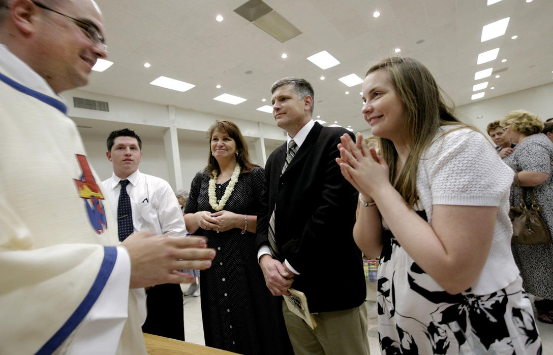 First Place, Feature Picture Story - Fred Squillante / The Columbus DispatchFather Robert Bolding (left) smiles at his sister, Tricia, far right. Bolding's family was first in a reception line to receive a blessing by the new priest. In front of Robert are (from left) his brother Nick, mom Patty, dad Al, and sister Tricia.