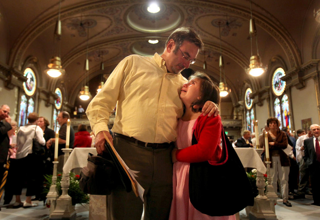 First Place, News Picture Story - Gus Chan / The Plain DealerMark Holan, left, of Cleveland, comforts his daughter, Annie, as the two were standing on the altar after the final mass at St. Procop Church.  The church closed it's doors for the final time after the morning service. 