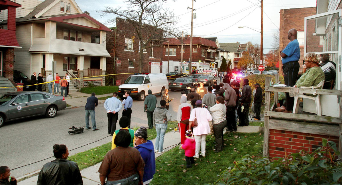 Second Place, News Picture Story - John Kuntz / The Plain DealerA crowd from the East 123rd Street and Imperial Avenue neighborhood gathered to watch as Cuyahoga County coroners and Cleveland police searched for bodies at the home of Anthony Sowell on the east side of Cleveland October 30, 2009.