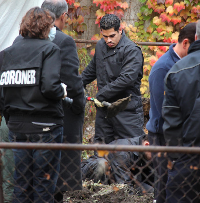 Second Place, News Picture Story - John Kuntz / The Plain DealerCuyahoga County coroners use shovels and a backhoe to clear dirt in the backyard at the home of Anthony Sowell as they exhume another body in the backyard November 3, 2009 in Cleveland's east side.  