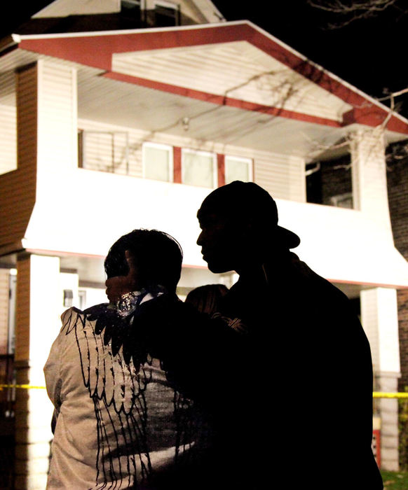 Second Place, News Picture Story - John Kuntz / The Plain DealerThe silhouette of a pair of curious onlookers watch as the Cleveland police and Cuyahoga County coroners search for the bodies of victims at the home of Anthony Sowell November 3, 2009 in Cleveland's east side.  The victim count is up to eleven and the search will continue inside the house tomorrow.