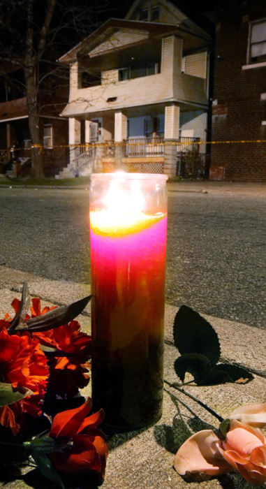 Second Place, News Picture Story - John Kuntz / The Plain DealerA lit prayer candle sits among flowers on the sidewalk at the corner of Imperial Avenue and East 123rd Street across the street from the home of alleged mass murderer Anthony Sowell November 12, 2009 after a candlelight vigil at the memorial site in Cleveland.