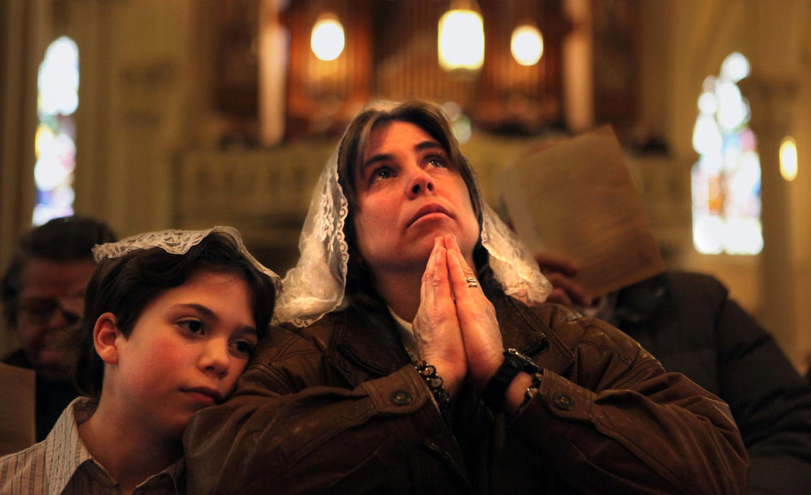 First Place, News Picture Story - Gus Chan / The Plain DealerAnn Christopher sits with her daughter Elizabeth, 10, during a prayer service at St. Stephen Church.  St. Stephen's was one of the Cleveland churches in danger of closing during the Catholic Diocese downsizing.