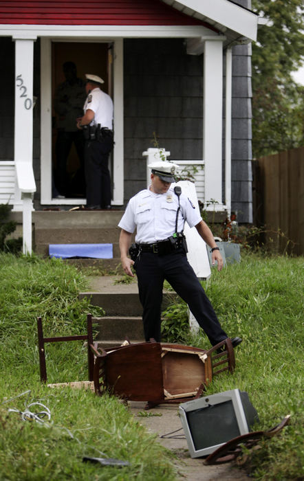 Third Place, News Picture Story - Courtney Hergesheimer / The Columbus DispatchColumbus police officers called to a domestic violence scene walk through a yard full of items that used to be in side the house, a result to a domestic dispute.