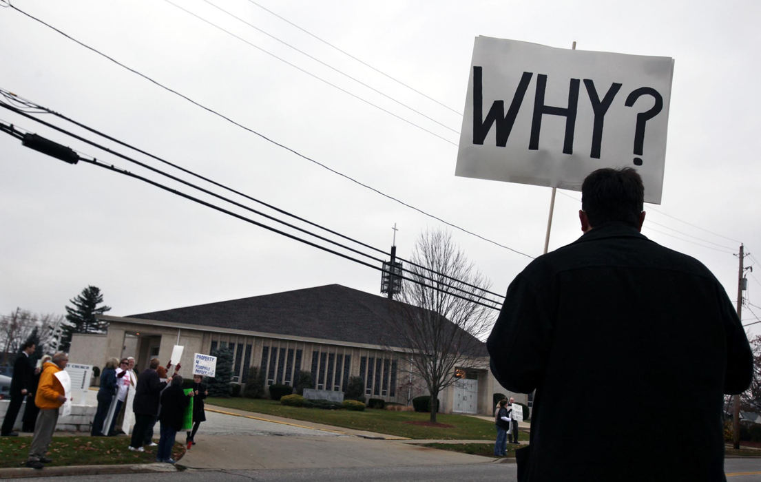 First Place, News Picture Story - Gus Chan / The Plain DealerAndy Toth, a former parishioner of the now closed St. Margaret of Hungary, protests outside St. Mary Church.   Bishop Richard Lennon presided over the final mass at the church this morning. 