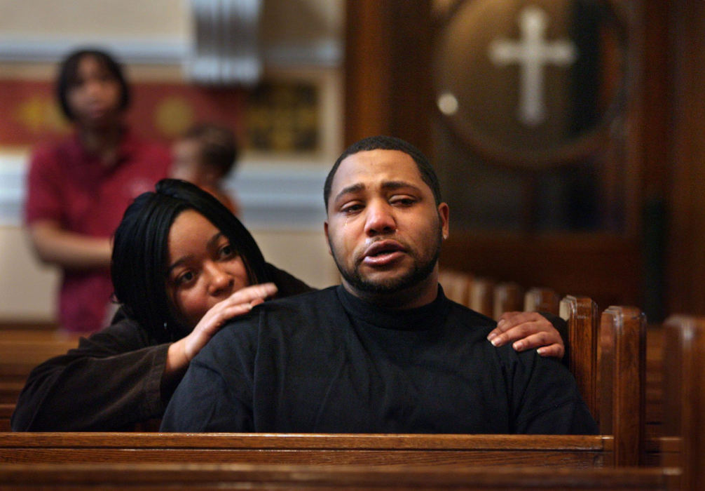 First Place, News Picture Story - Gus Chan / The Plain DealerGeorge Gamble is comforted by Lisa Sullivan after hearing the Church of St. Adalbert, the city's first black Catholic church, will close it's doors as part of the diocese downsizing.  Gamble has spent his entire 26 years in the church.  He was baptized, made his first communion and confirmation at the church, and came back to work at St. Adalbert School after graduating from college.