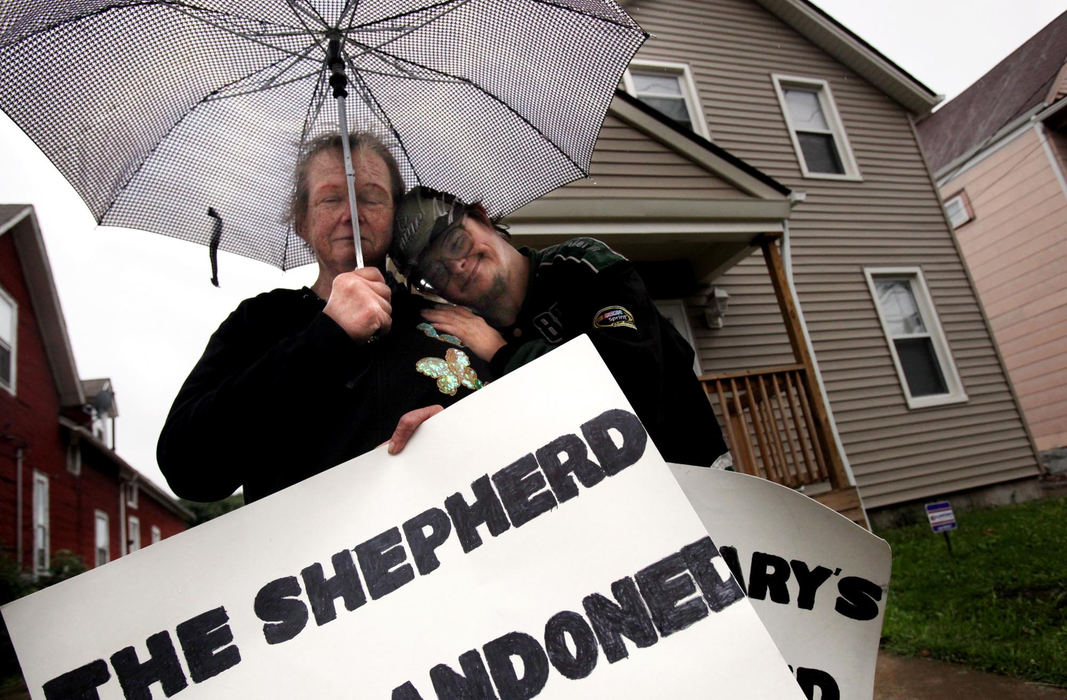 First Place, James R. Gordon Ohio Understanding Award - Gus Chan / The Plain DealerAnn Marie Schafle and her son, Joseph, protest outside of St. Procop Church during the final mass.  